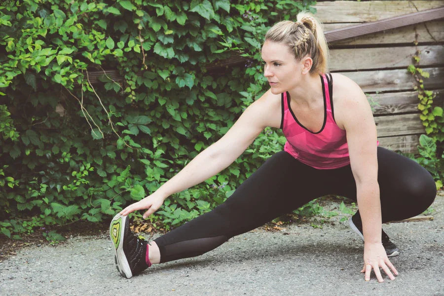 Woman stretching on mat as part of a home workout routine.